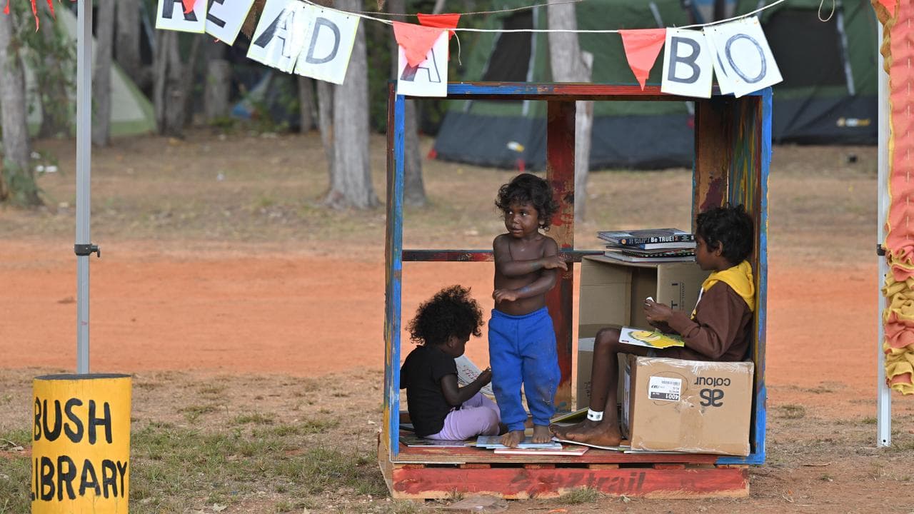 Aboriginal children read books at a bush library (file image)