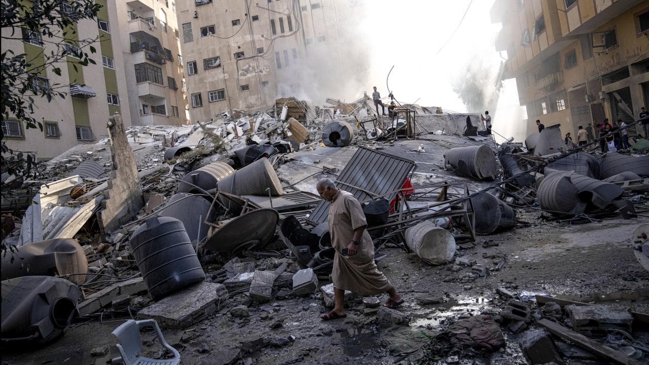 Palestinians inspect the rubble of a building in Gaza City