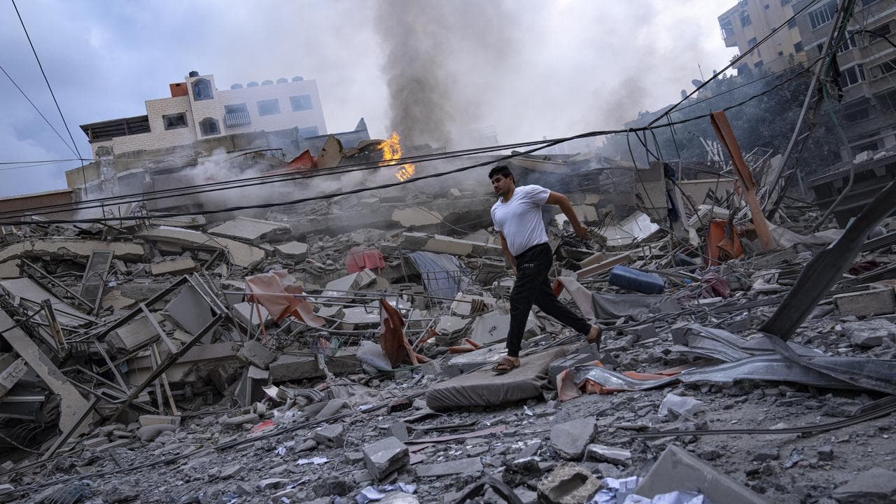 A Palestinian walks amid the rubble after Israeli air strikes in Gaza