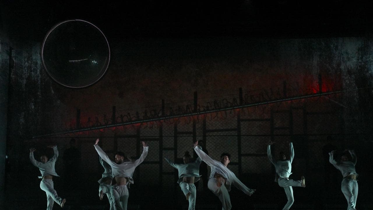 Dancers in white against a dark background