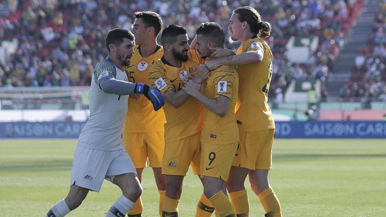 Socceroos players celebrate a goal.