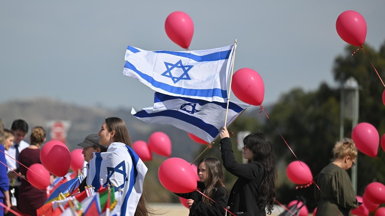 Flags and balloons representing kidnapped Israelis in Gaza at a rally