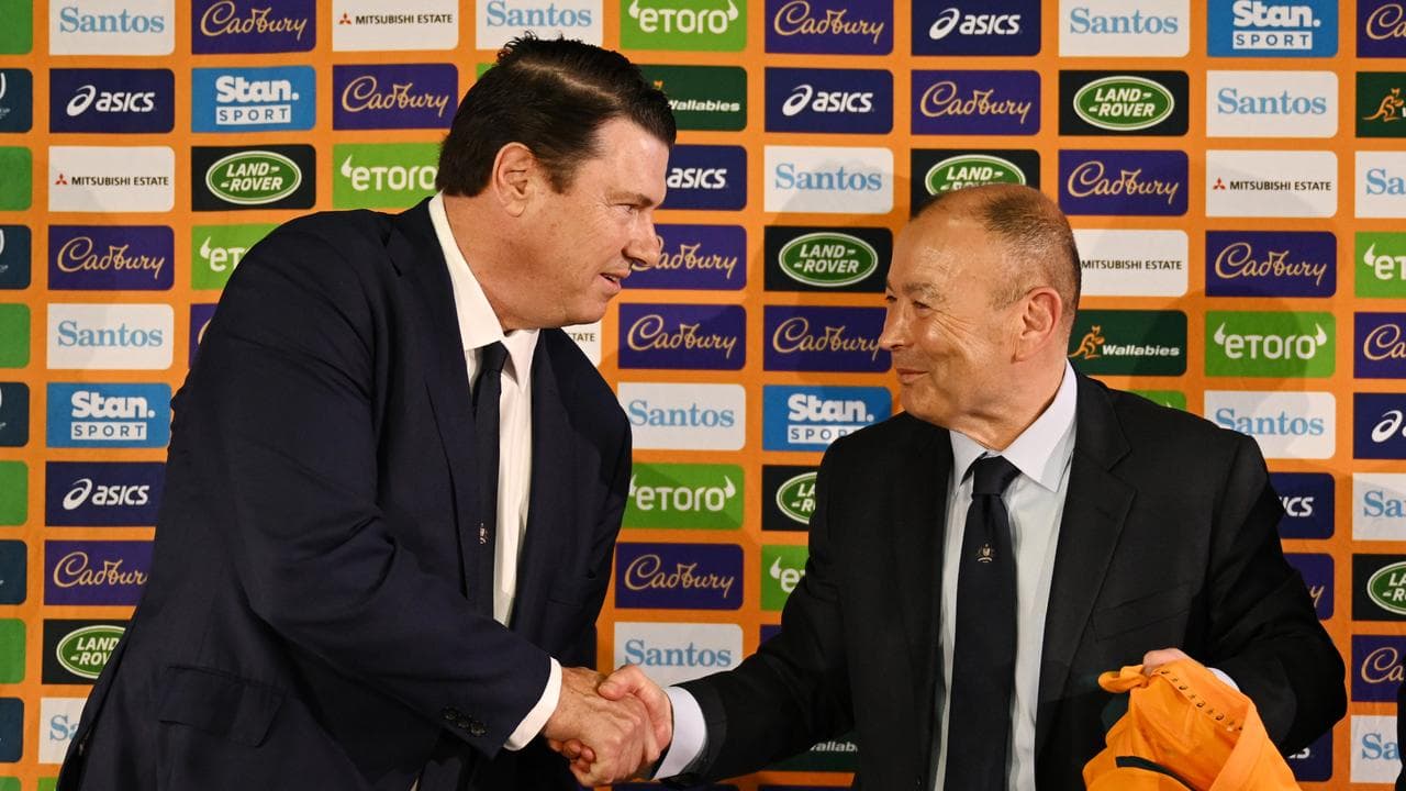 McLennan shakes hands with Jones at a press conference.