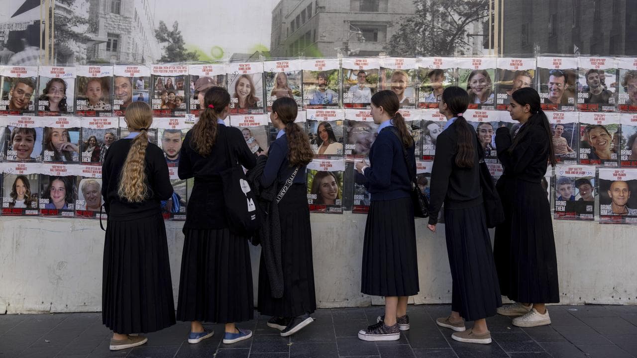 Women look at photos of Israelis missing and held captive in Gaza