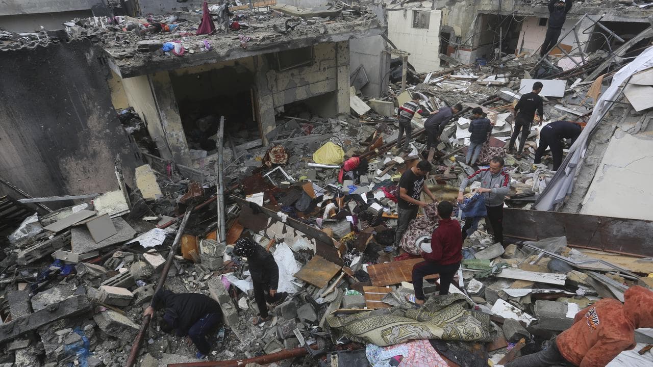 Palestinians salvage their belongings after an Israeli strike in Rafah