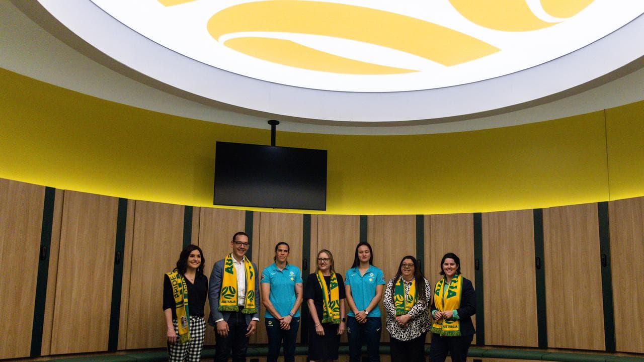 Officials and players post in a dressing room.