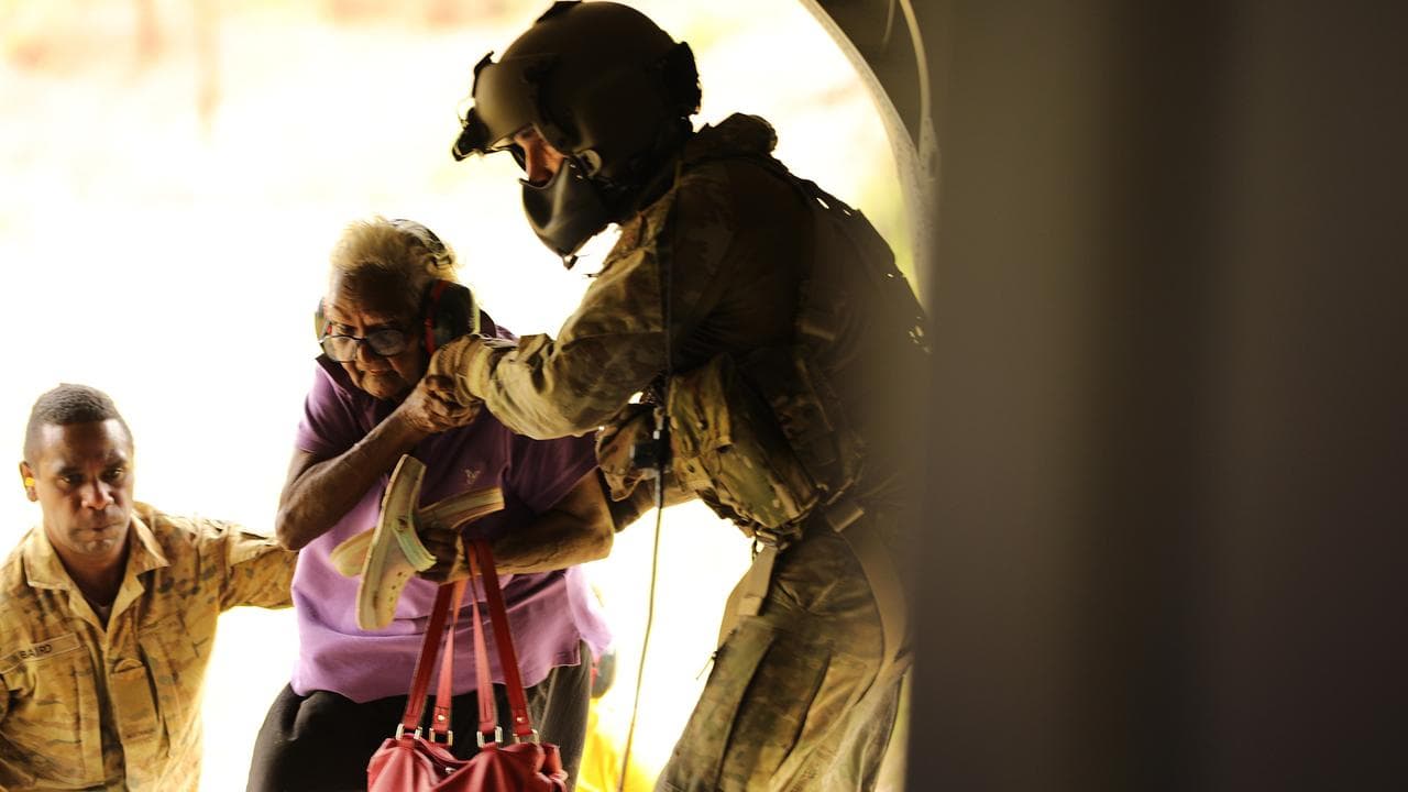 Soldiers helping a resident to evacuate from Wujal Wujal