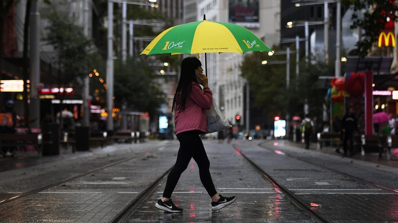 People walk with umbrellas in Sydney