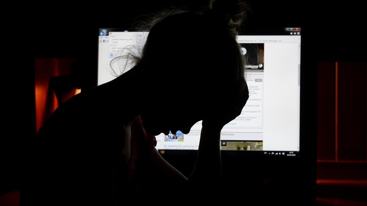 A file image depicting an upset young girl in front of a computer