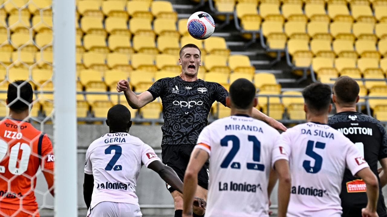 Wellington's Finn Surman heads the ball against Victory. 