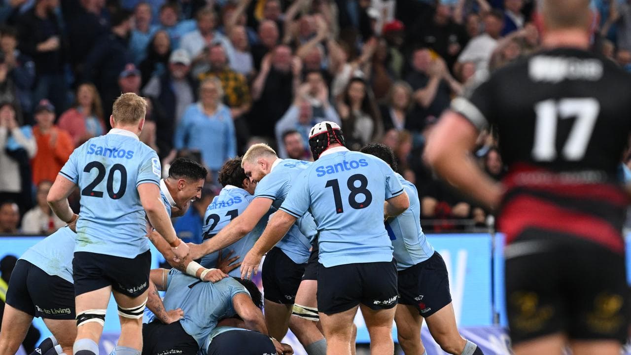 The ecstatic Waratahs mob Harrison after his crucial field goal.