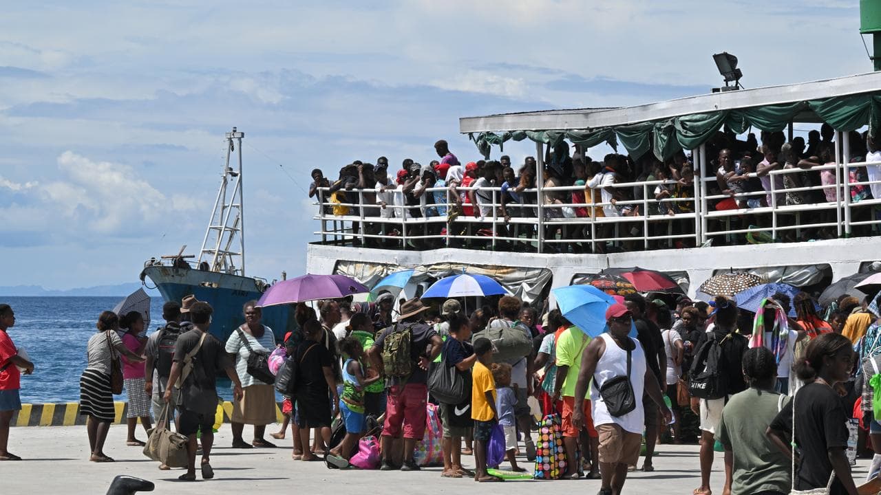People wait to board a crowded ferry in Honiara