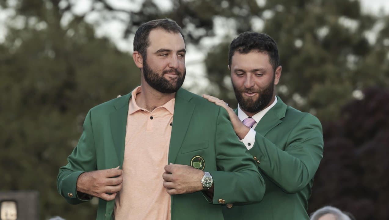 Scheffler (left) receives Masters green jacket from Jon Rahm.