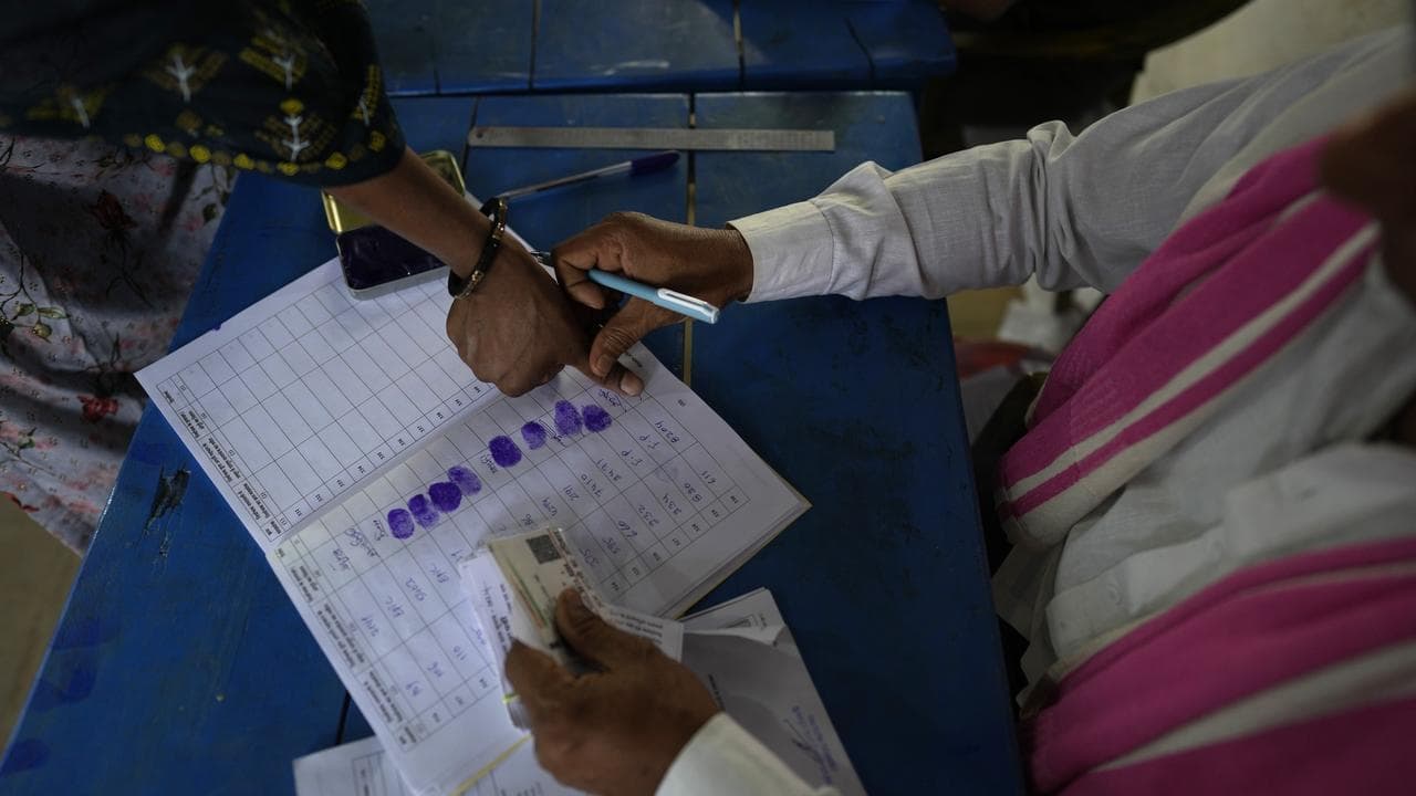A woman puts her thumb mark before casting a vote in Behror, India 