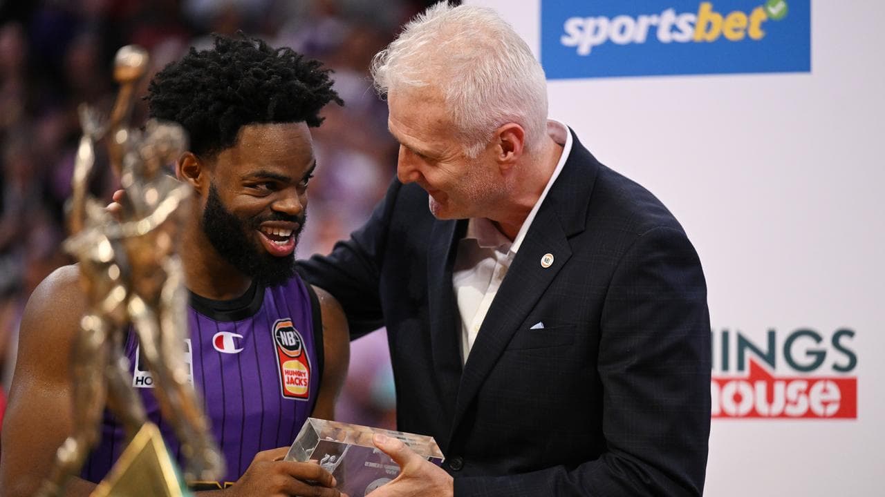 Derrick Walton Jr receives the MVP award from Andrew Gaze