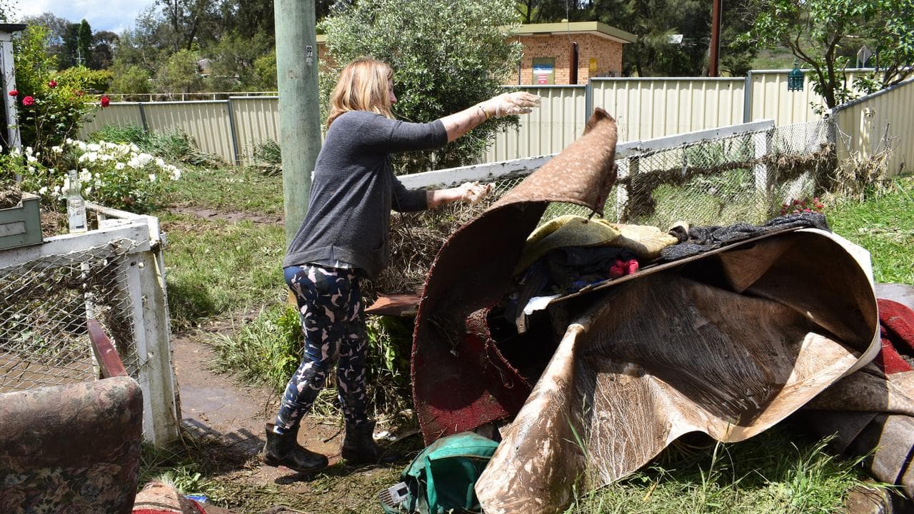 A volunteer helps empty the house of an elderly woman.