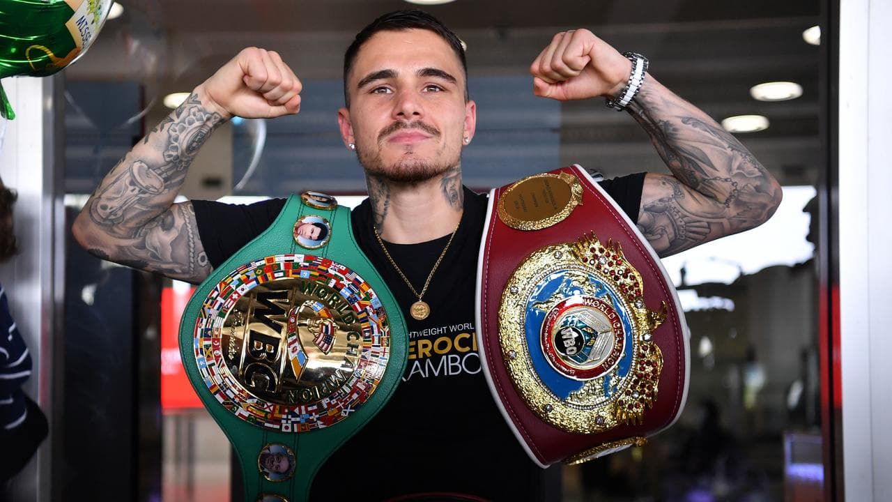 George Kambosos shows off his world title belts in 2021.