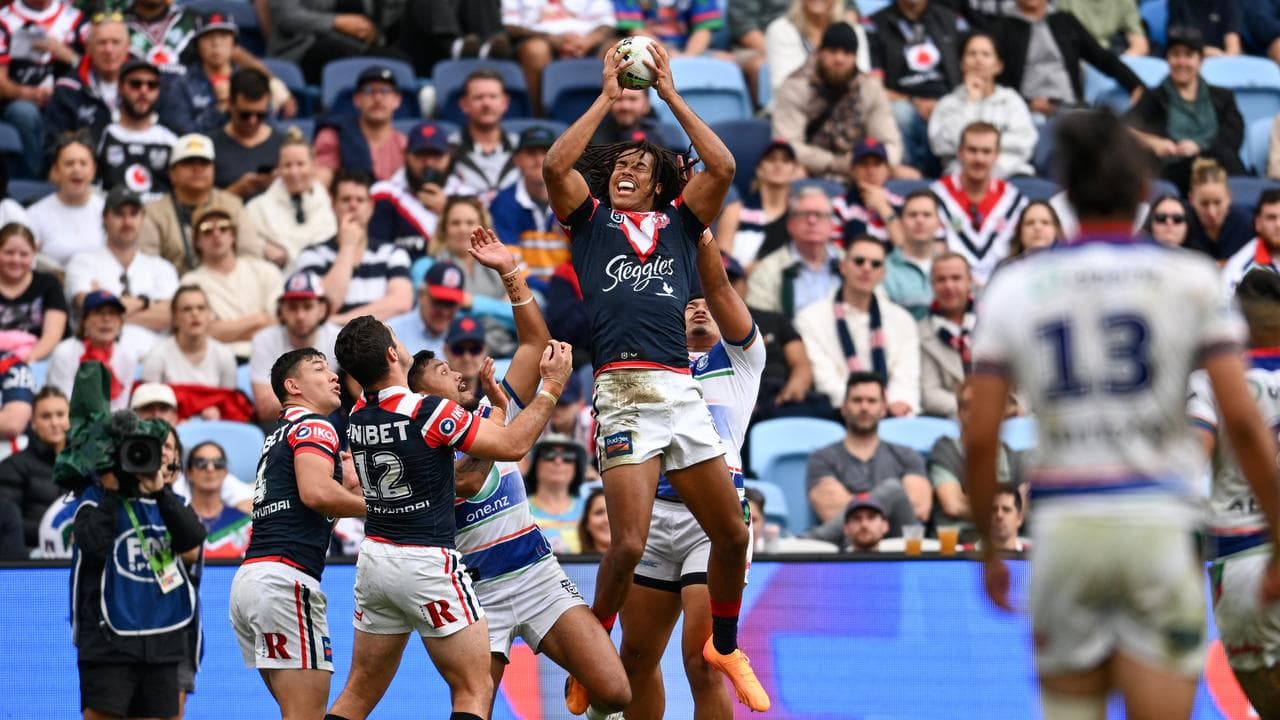 Dominic Young of the Roosters catches the ball against the Warriors.