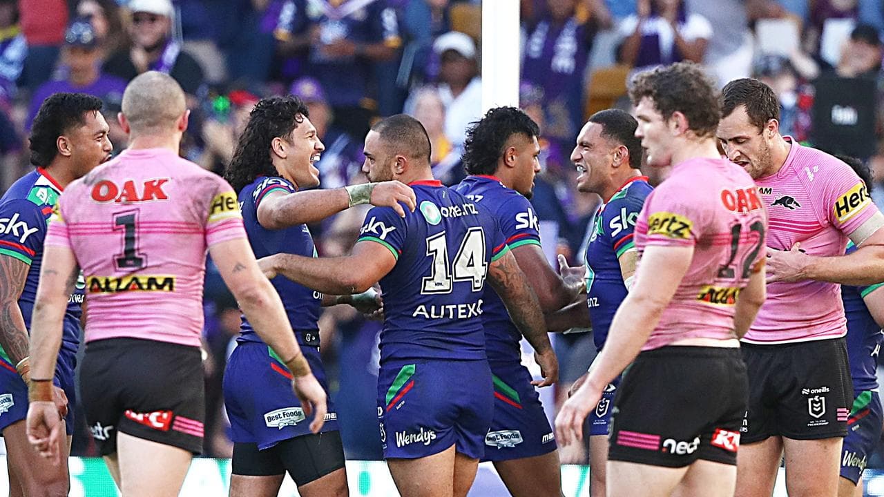 Warriors players celebrate a try as dejected Panthers look on.