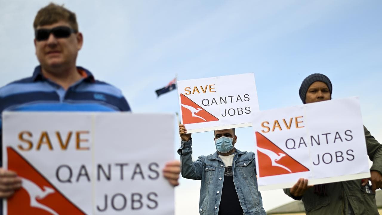 Qantas employees hold signs during a rally (file image)