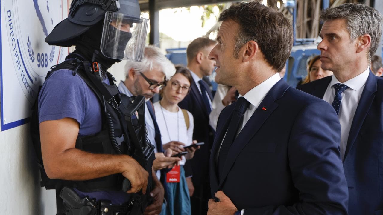 French President Emmanuel Macron arriving at Noumea police station