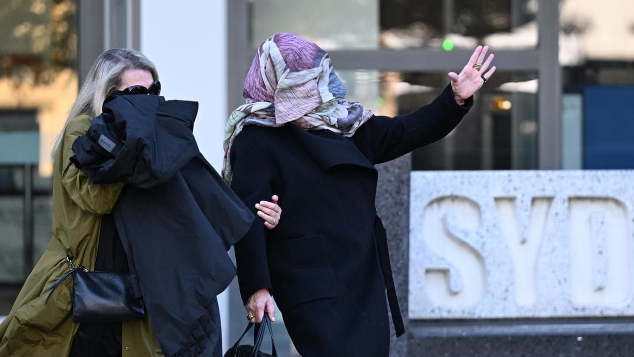Annemie Stein (right) covers her face as she leaves court