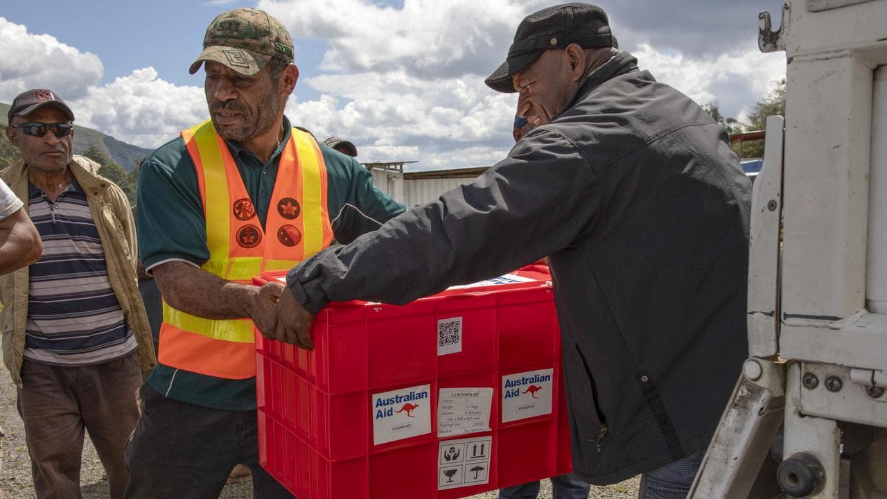 Locals unload aid from Australia in the hHighlands of Papua New Guinea