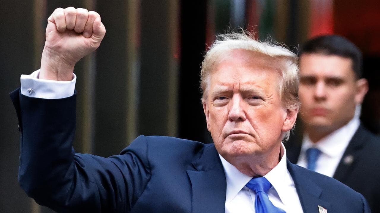 Donald Trump gestures to the crowd outside Trump Tower
