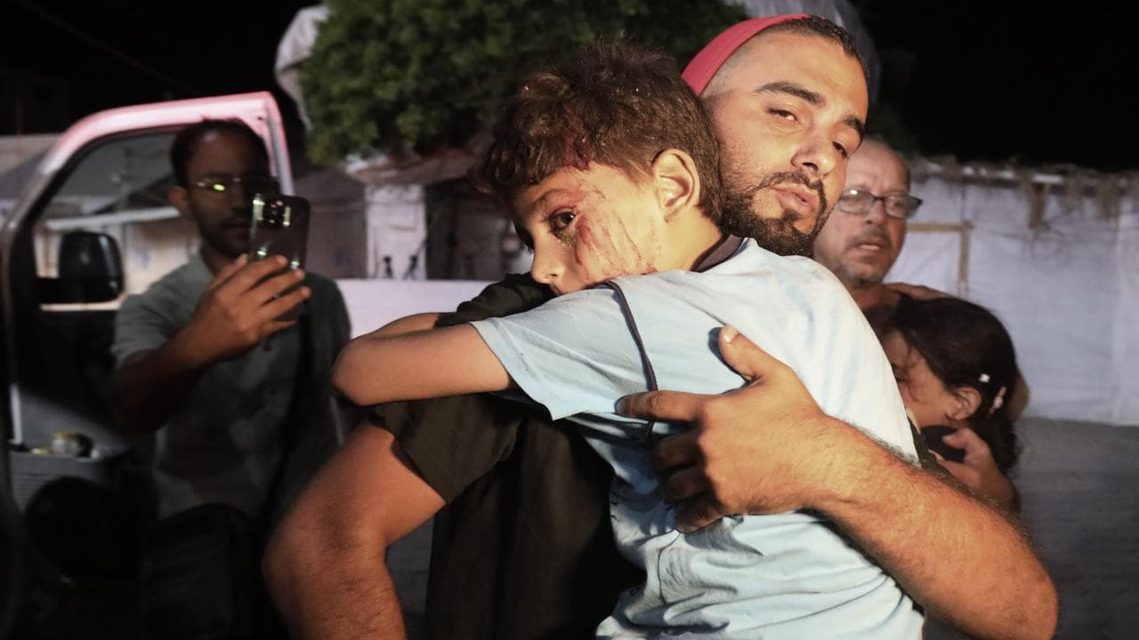 Palestinians help wounded children in an Israeli bombardment in Gaza
