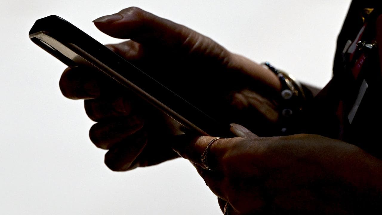 An image of a person typing on their mobile phone.