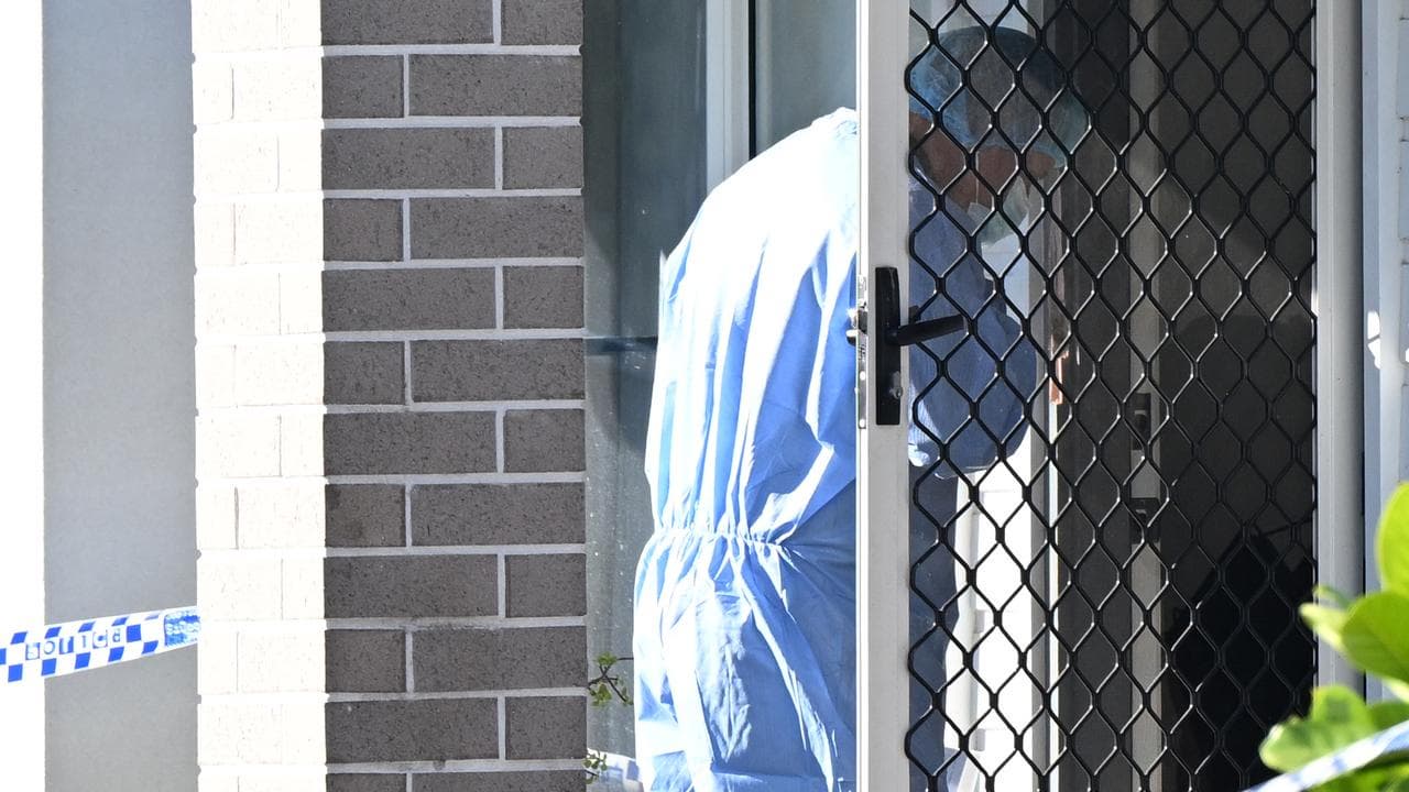 A crime scene officer at the front door of a home.