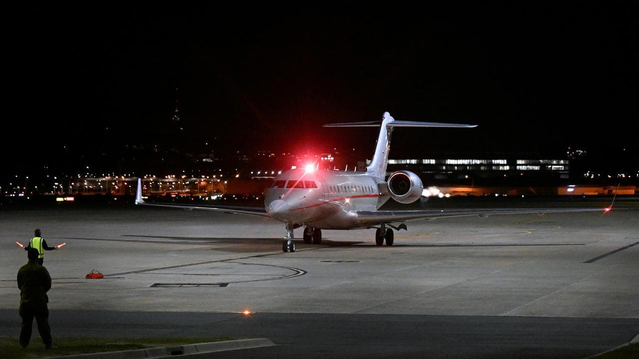A plane carrying Julian Assange arrives in Canberra.