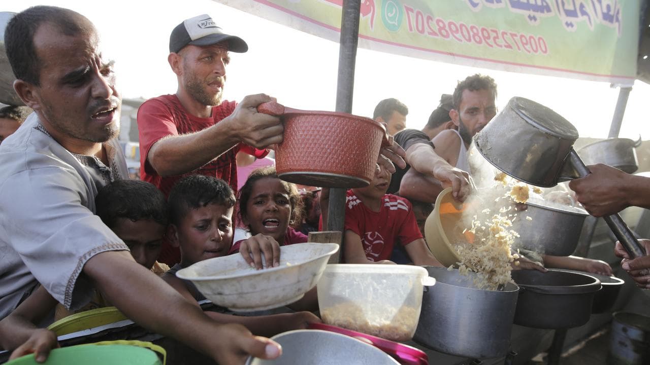 Palestinians collect food aid ahead in Khan Younis in the Gaza Strip