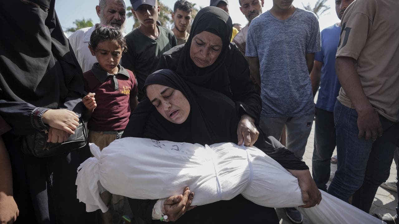 A woman holds the body of her daughter in Maghazi refugee camp, Gaza
