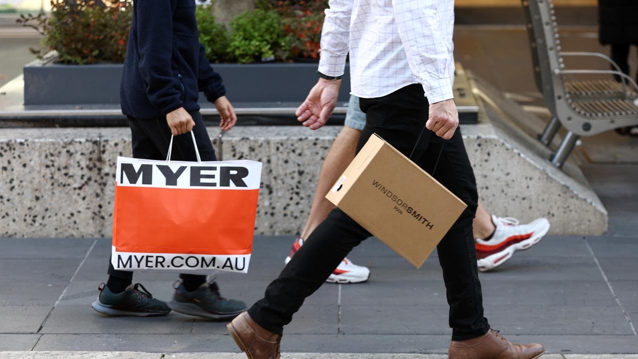 People walk along Bourke Street with shopping bags