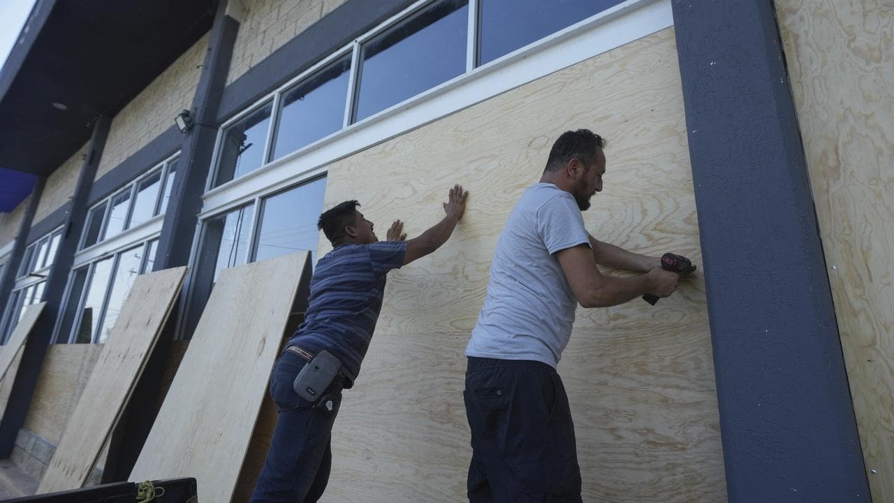 Furniture store employees board up windows in Playa del Carmen, Mexico