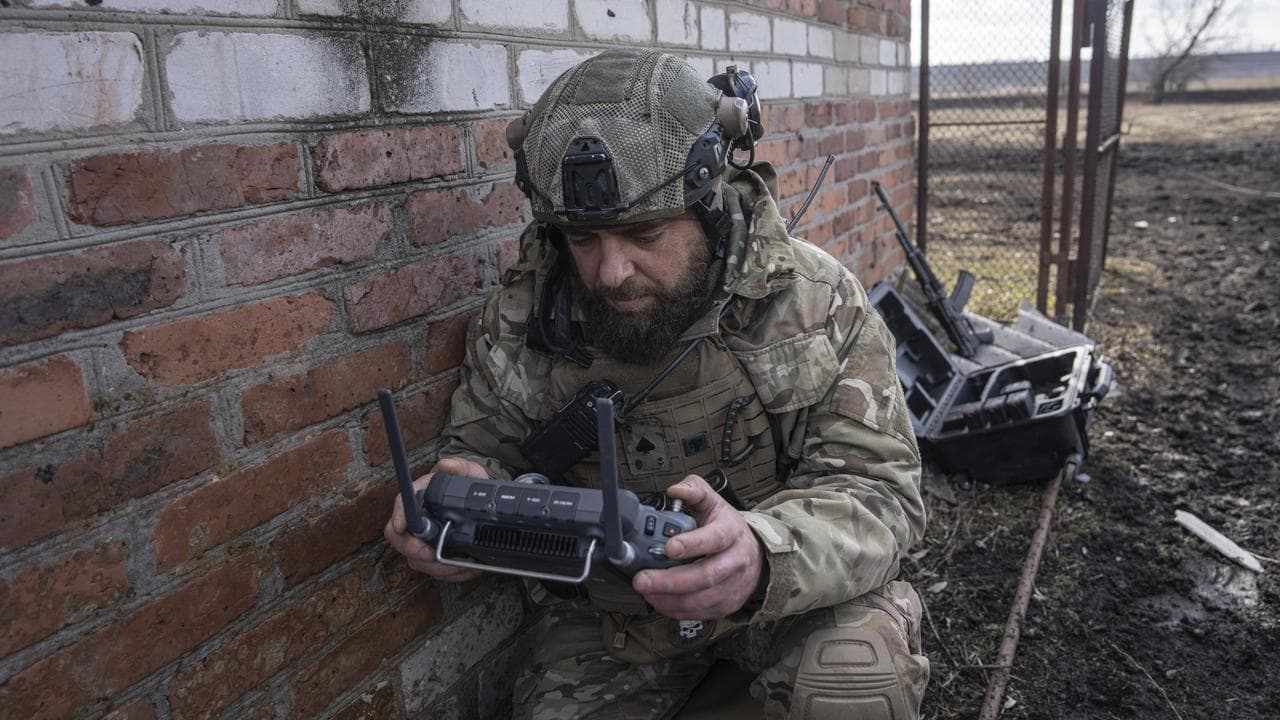 A soldier uses a remote control for a drone.