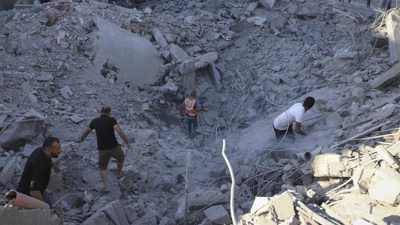 Palestinians search the rubble after an Israeli strike in Khan Younis