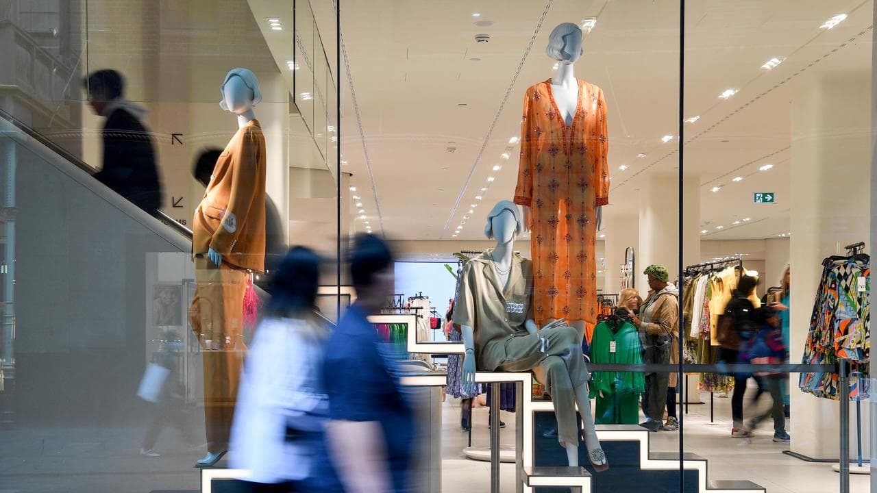 Pedestrians walk past a retail shopfront