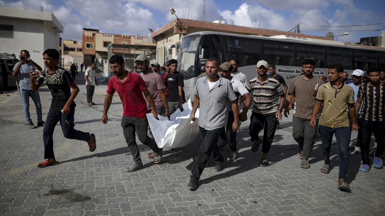 Palestinians carry a body after an Israeli bombardment in Khan Younis