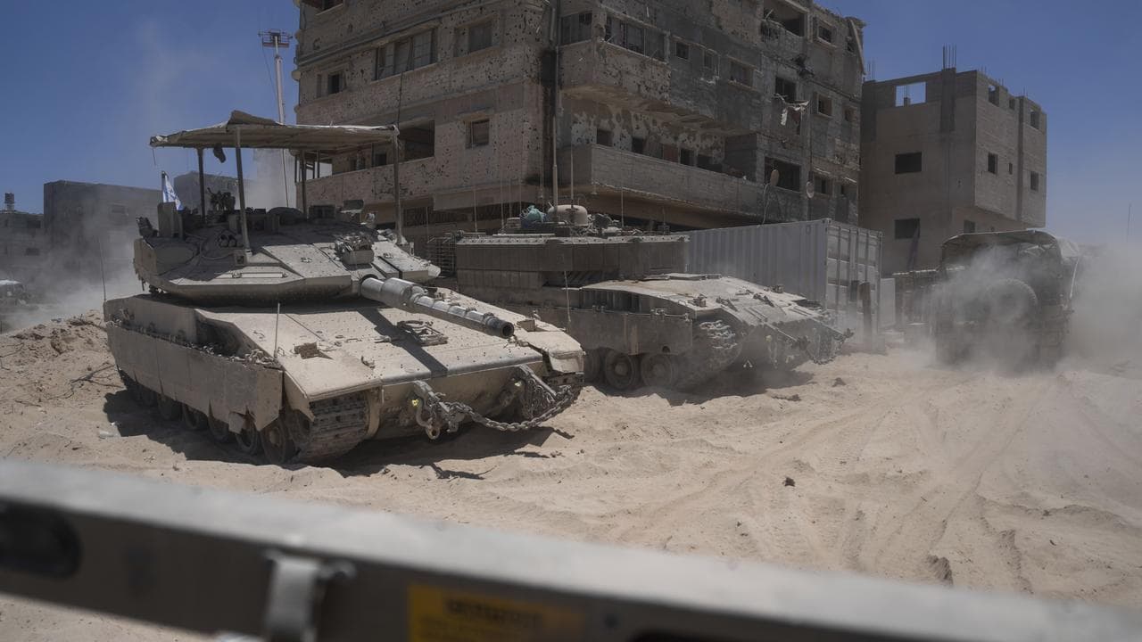 Israeli tanks next to destroyed buildings in the southern Gaza Strip
