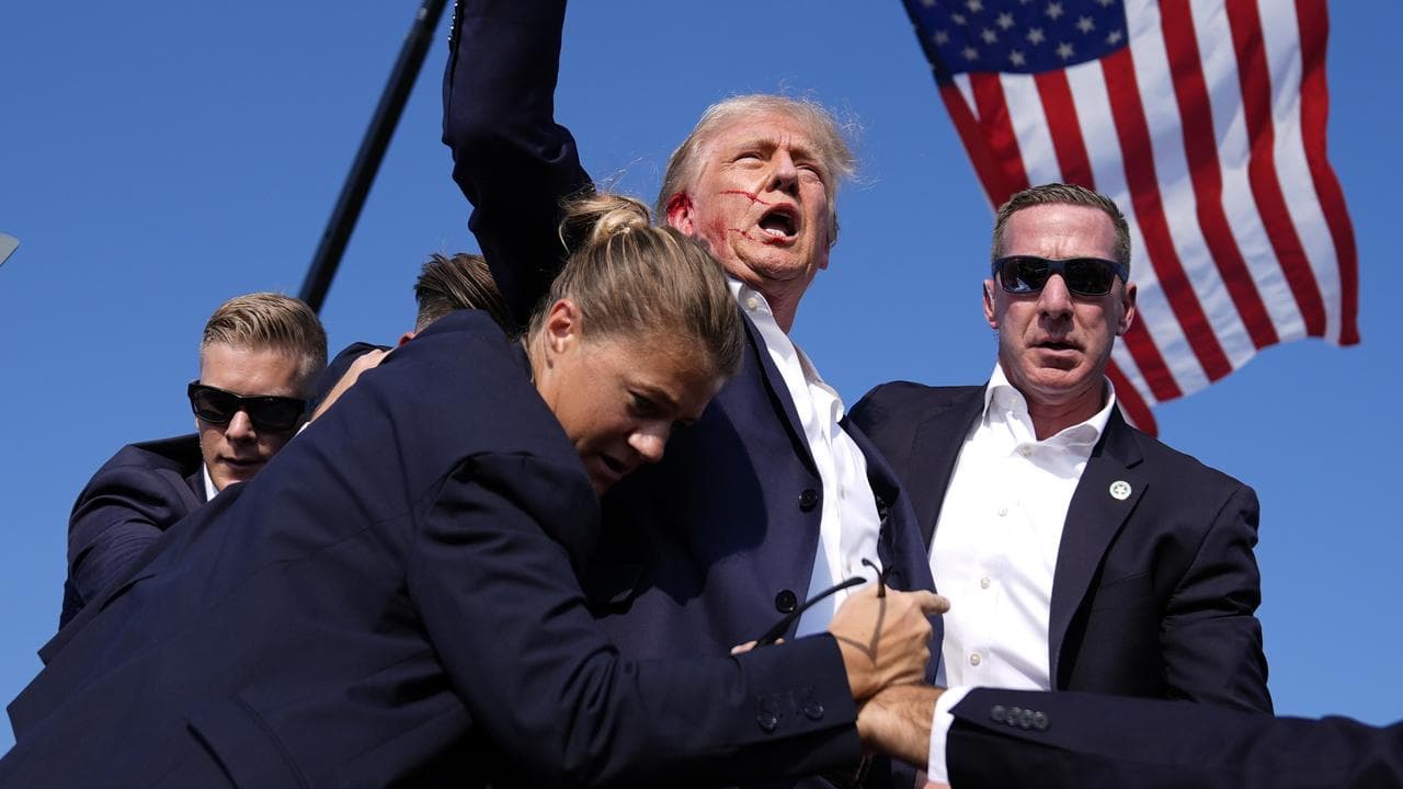 Donald Trump surrounded by US Secret Service agents after shooting