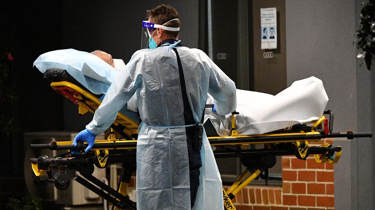 Healthcare workers transport a person into a patient transport vehicle