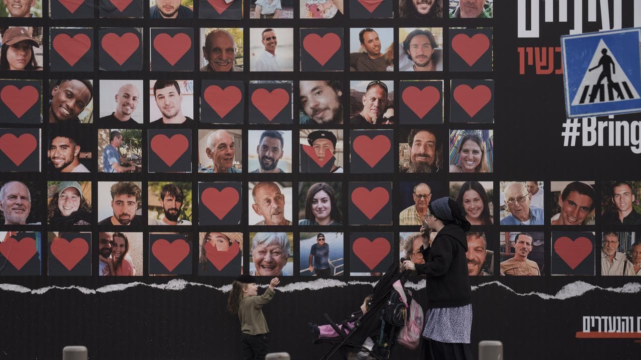 A wall with photographs of hostages who were kidnapped on October 7
