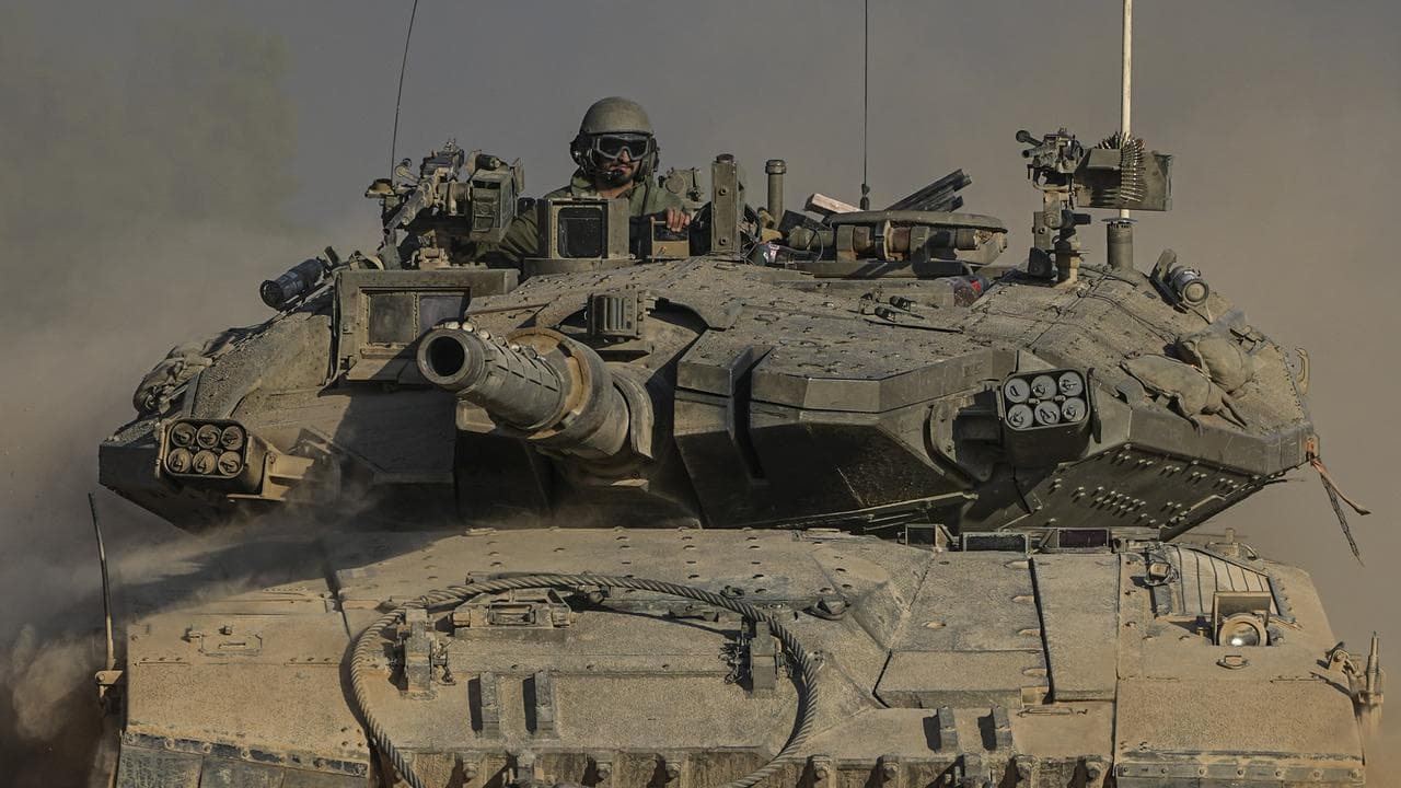 An Israeli soldier moves on the top of a tank near the Gaza border