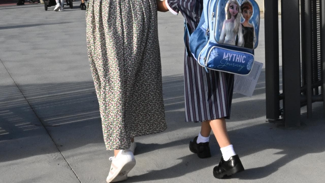 A mother and girl walking to school.
