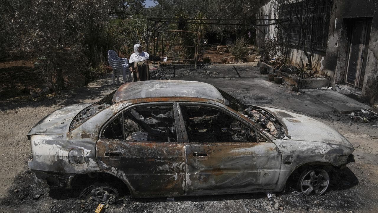 A Palestinian woman outside her home torched by Jewish settlers.