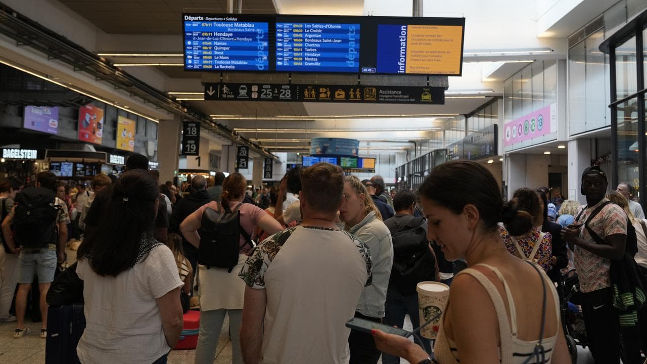 Travellers check an electronic board at the Gare de Montparnasse