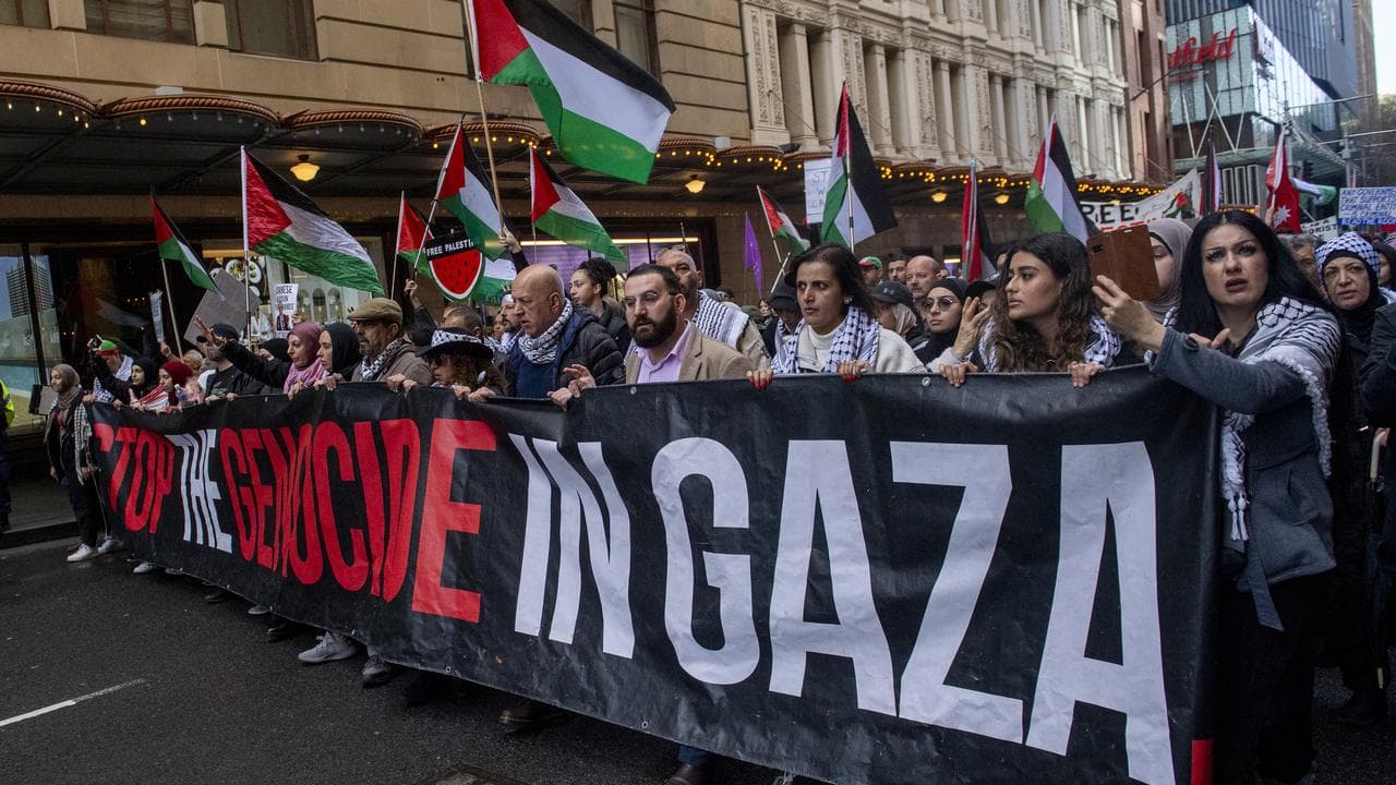 Protesters hold a sign.