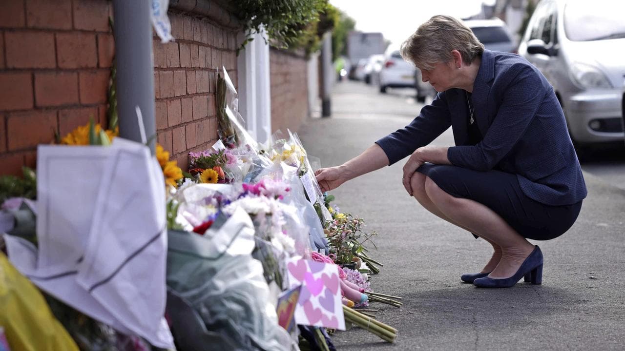 British Home Secretary Yvette Cooper leaves flowers